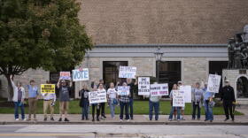 Scott County Democrats hold signs. (Chris Bentley/Here & Now)