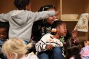 Lola Davis sits on the lap of her teacher, Starasia Goodwin, while reading with friends at Fun Times With Titi Childcare on Monday, October 27, 2025.