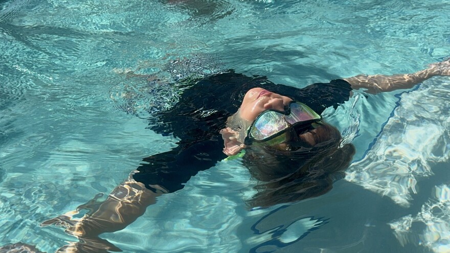 A child learns how to float on their back during the World's Largest Swimming Lesson event at Margaritaville in Fort Myers Beach.