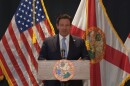 Gov. Ron DeSantis speaking at a press conference in Manatee County, Florida, on July 24, 2025. He stands behind a podium with the state seal on it.