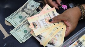 A woman shows her Mega Millions tickets hours before the draw of the $1 billion jackpot, at the Bluebird Liquor store in Torrance, Calif., Oct. 19, 2018. (Mark Ralston/AFP/Getty Images)