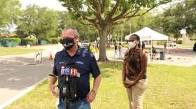 Orlando Mayor Buddy Dyer addresses the media at a testing site in West Orlando as commissioner Regina Hill looks on. Photo: Matthew Peddie, WMFE