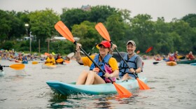 Two people paddle in a kayak on the Ohio River