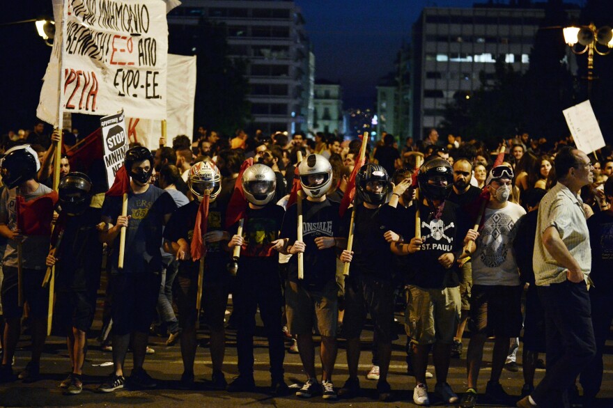 Protesters stand in front of thre Greek parliament in Athens during an anti-austerity protest on Wednesday.
