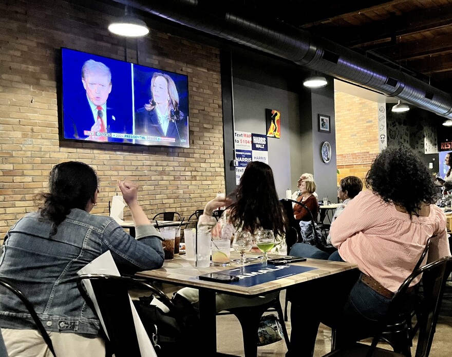 Attendees listen to President Donald Trump and Vice President Kamala Harris during a Democratic debate watch party Tuesday night at Voodoo Brewing Co. in Scranton.