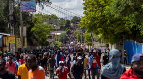 People gather in Port-au-Prince during a protest against the government and the US as the nation celebrates the 216th anniversary of the assassination of Haitian independence hero Jean-Jacques Dessalines.