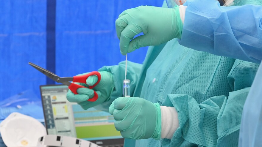 Health care workers place a nasal swab from a patient into a tube for testing at the Brightpoint Health and UJA-Federation of New York pop-up coronavirus testing site on Friday in New York City.