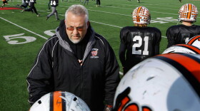 Washington Community High School coach Darrell Crouch talks with his team during football practice at Illinois State University's Hancock Stadium Wednesday, Nov. 20, 2013, in Normal, Ill. The team has a state semifinal playoff game Saturday, but their hometown is just digging out from a powerful tornado that destroyed a number of players' homes. Practice had to be moved, in part, because the high school has no drinkable water service. (AP Photo/Seth Perlman)