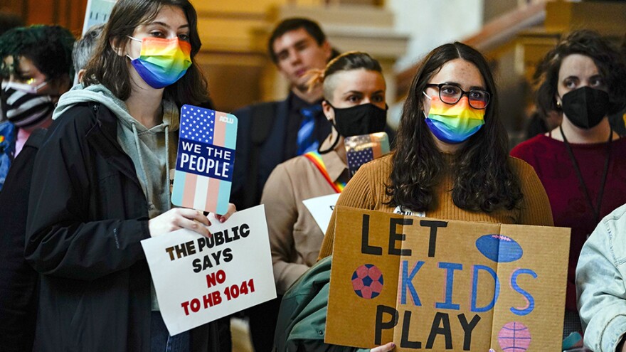 People gather to protest against HB1041, a bill to ban transgender women and girls from participating in school sports that match their gender identity, during a rally at the Statehouse in Indianapolis, Wednesday, Feb. 9, 2022. The Republican-backed bill drew nearly three hours of testimony on Wednesday, as lawmakers considered whether to further advance the bill.