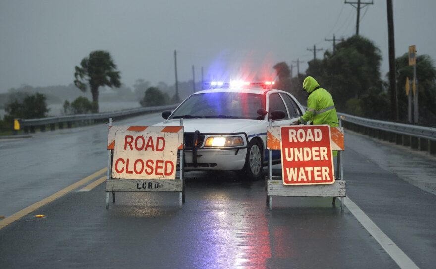 Police block the road entering Cedar Key, Fla., as Hurricane Hermine nears the Florida coast, Thursday, Sept. 1, 2016. (AP Photo/John Raoux)