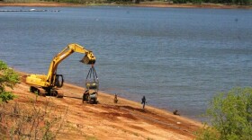 Heavy equipment is moved into a place to help fish a crane from Kaw Lake.