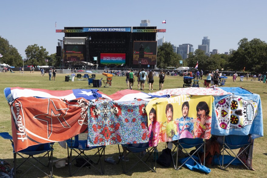 Festival-goers set up seats with towels over them as protection from the sun.