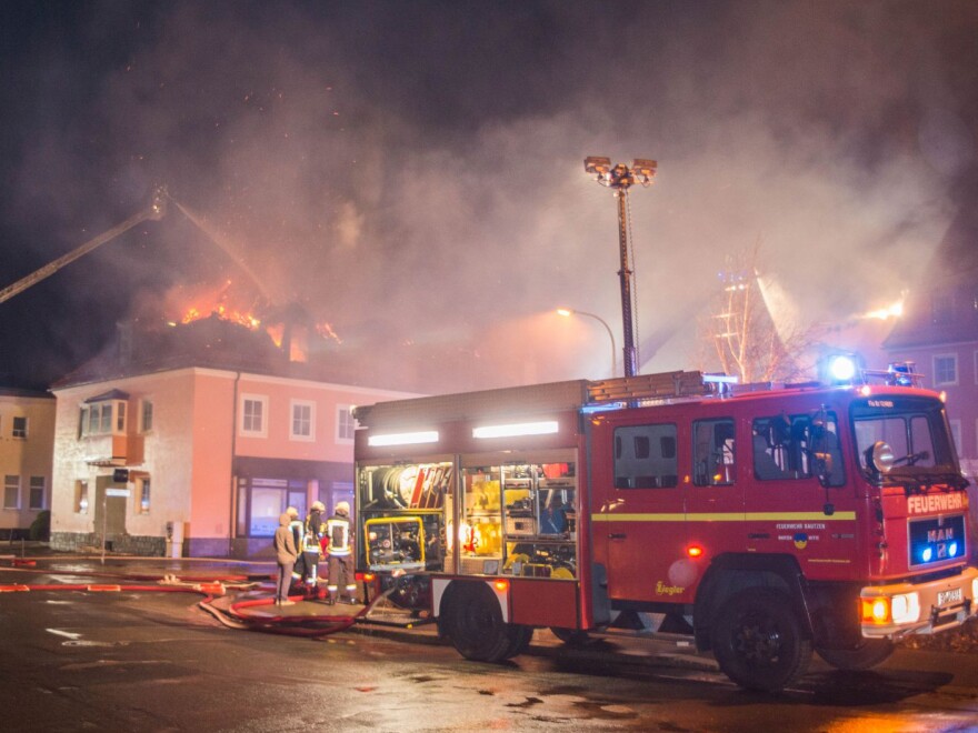 Firefighters try to extinguish a blaze Feb. 16 at a former hotel under reconstruction to become a home for asylum seekers in Bautzen, Germany. A crowd cheered and chanted anti-migrant slogans during the fire, which is being investigated as arson.
