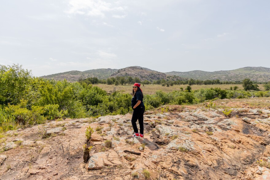 Kaysa Whitley (Kiowa/Absentee Shawnee) walks around the Wichita Mountains Wildlife Refuge on July 17, 2025. It's about 13 miles away from the Westwin Elements demonstration plant. "[There's] something about these mountains, something about the land, the area. It calls to me, and I just always end up coming back here," Whitley said.
