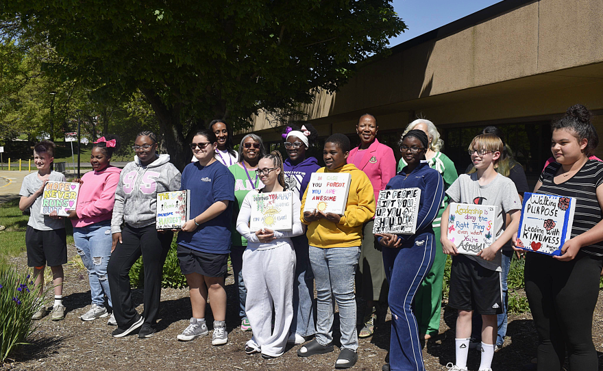 Students and sorority leaders smile with stepping stones the students designed.