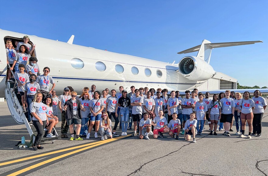 Students from the Jim Shaw ACE Academy pose in front of plane