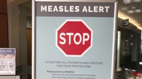 File - In this Jan. 30, 2019, file photo, a sign posted at The Vancouver Clinic in Vancouver, Wash., warns patients and visitors of a measles outbreak. The focus on measles in the Pacific Northwest intensified Friday, March 1, 2019, as public health officials in Oregon announced a new case of the highly contagious disease unrelated to an ongoing outbreak in Washington state that's sickened 68 people so far.