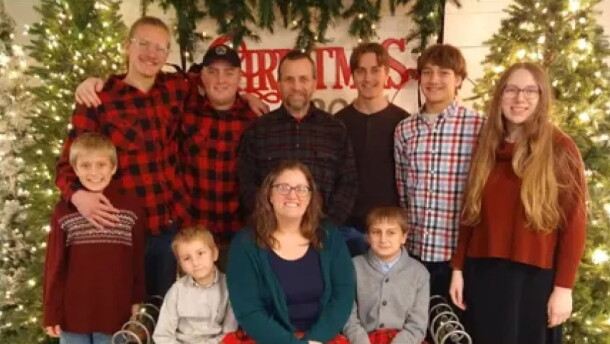 10 members of a family posed in front of a Christmas tree