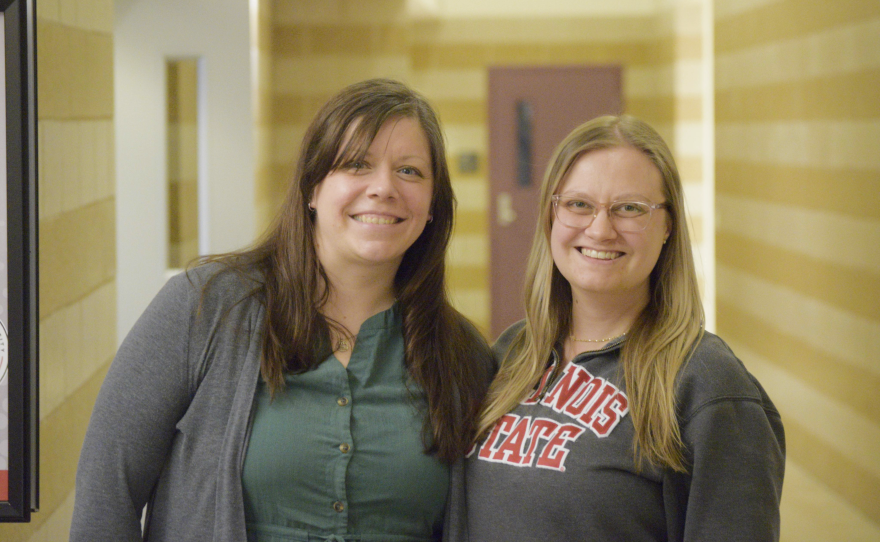Woman, left, in green button-up top. Beside her is a woman in a gray Illinois State branded sweatshirt.
