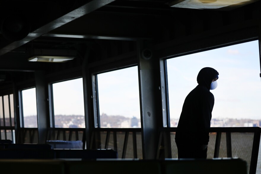 Tremaine Fredericks rides a nearly empty Staten Island Ferry to Manhattan in New York City. Gov. Andrew Cuomo's "New York State on PAUSE" executive order went into effect on March 22.