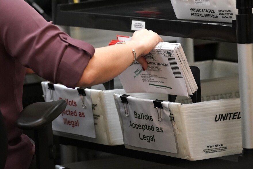 In this Oct. 26, 2020, file photo an election worker sorts vote-by-mail ballots at the Miami-Dade County Board of Elections in Doral, Fla.