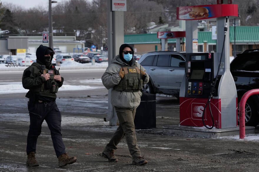 ICE agents walk through a gas station, Jan. 19, 2026, in St. Paul, Minn.