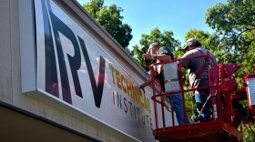 Workers put final touches on the front sign of the new RV Technical Institute in Elkhart.