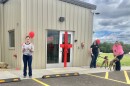 Libby Aeschleman, Tazewell County Animal Control director, speaks at a ribbon cutting ceremony for the county's new animal control facility in Tremont. Administrative Specialist Kira Thomas (black shirt) and Kennel Services Lead Jordan VonRohr are with Randy and Ryder, who later tore down the ribbon.