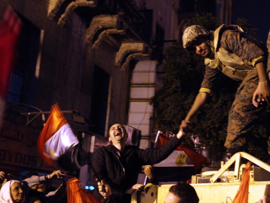An Egyptian anti-government protester laughs as he shakes the hand of a soldier during celebrations at Cairo's Tahrir Square on Feb 11 after president Hosni Mubarak stepped down. Flag-waving Egyptians danced, sang and cheered as they bid farewell to Hosni Mubarak's 30-year regime, but triumph was tempered with apprehension as they looked ahead to military rule.