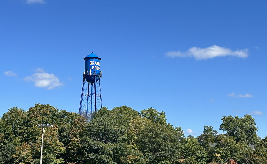 A bright blue water tower that reads "Grand Ledge" in yellow text