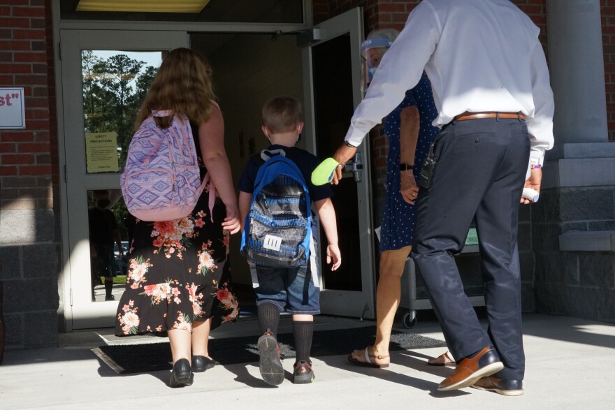 Riversink students are guided to the building's entrance by school staff.