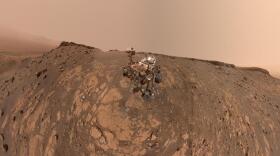 This selfie was taken by NASA's Curiosity Mars rover on Feb. 26, 2020 (the 2,687th Martian day, or sol, of the mission). The crumbling rock layer at the top of the image is the Greenheugh Pediment, which Curiosity climbed soon after taking the image. Directly to the left of Curiosity's foremost wheel is a hole the rover drilled at a rock feature called "Hutton." The selfie includes 86 individual images taken by the Mars Hand Lens Imager (MAHLI) camera on the end of Curiosity's robotic arm. The images were then stitched into a panorama.