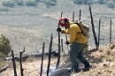 A North Summit firefighter works on a small brush fire that ignited near the southern end of Coalville's Main Street June 27, 2025.