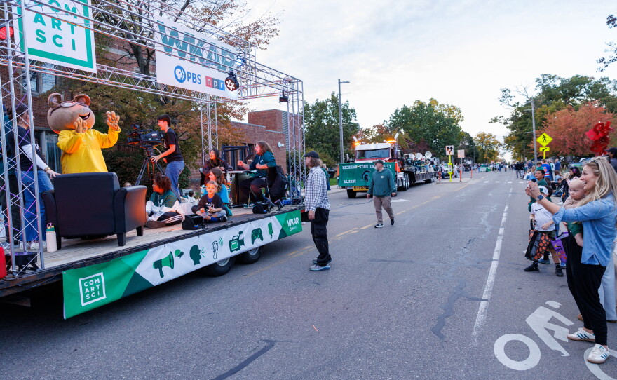Katie Faett takes a picture of the joint WKAR and College of Communication Arts and Sciences float during the Michigan State University Homecoming Parade in East Lansing, Mich., on Oct. 9, 2026.