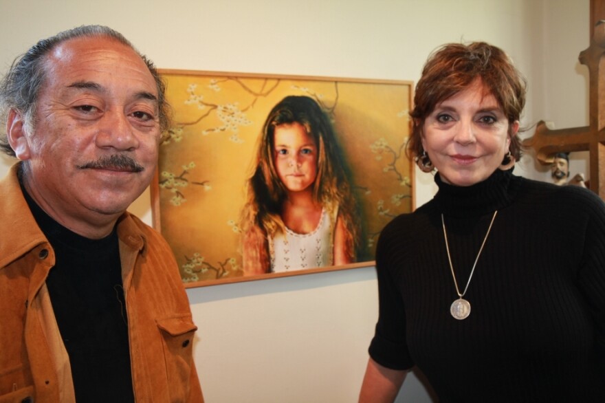 Jody and Reynaldo Terrazas stand in front of a painting of their oldest daughter. The Terrazases have lived in Oakland's San Antonio neighborhood for more than 40 years and raised two girls there.