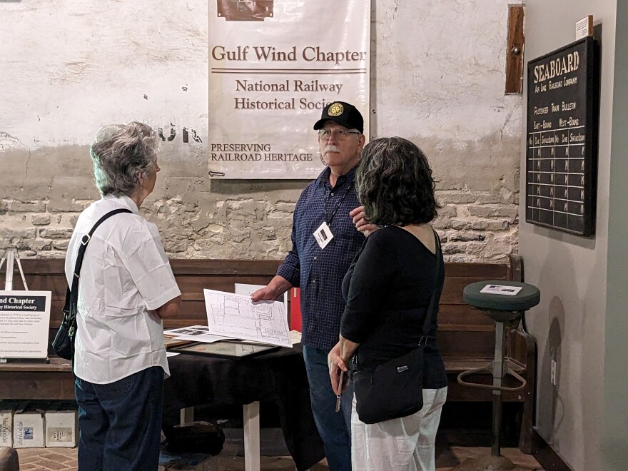 Gulf Wind Chapter National Railway Historical Society President Dave Hodges speaking with visitors to the Lloyd Depot open house.