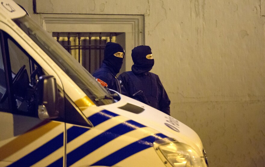 Police stand guard around the central police headquarters in Brussels on Thursday.