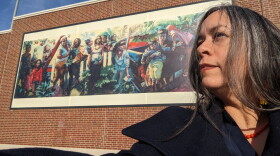 Teresa Dunn stands in front of A Long Line of Women, her artwork now adorning the Lansing Board of Water and Light REO Town Central Substation.