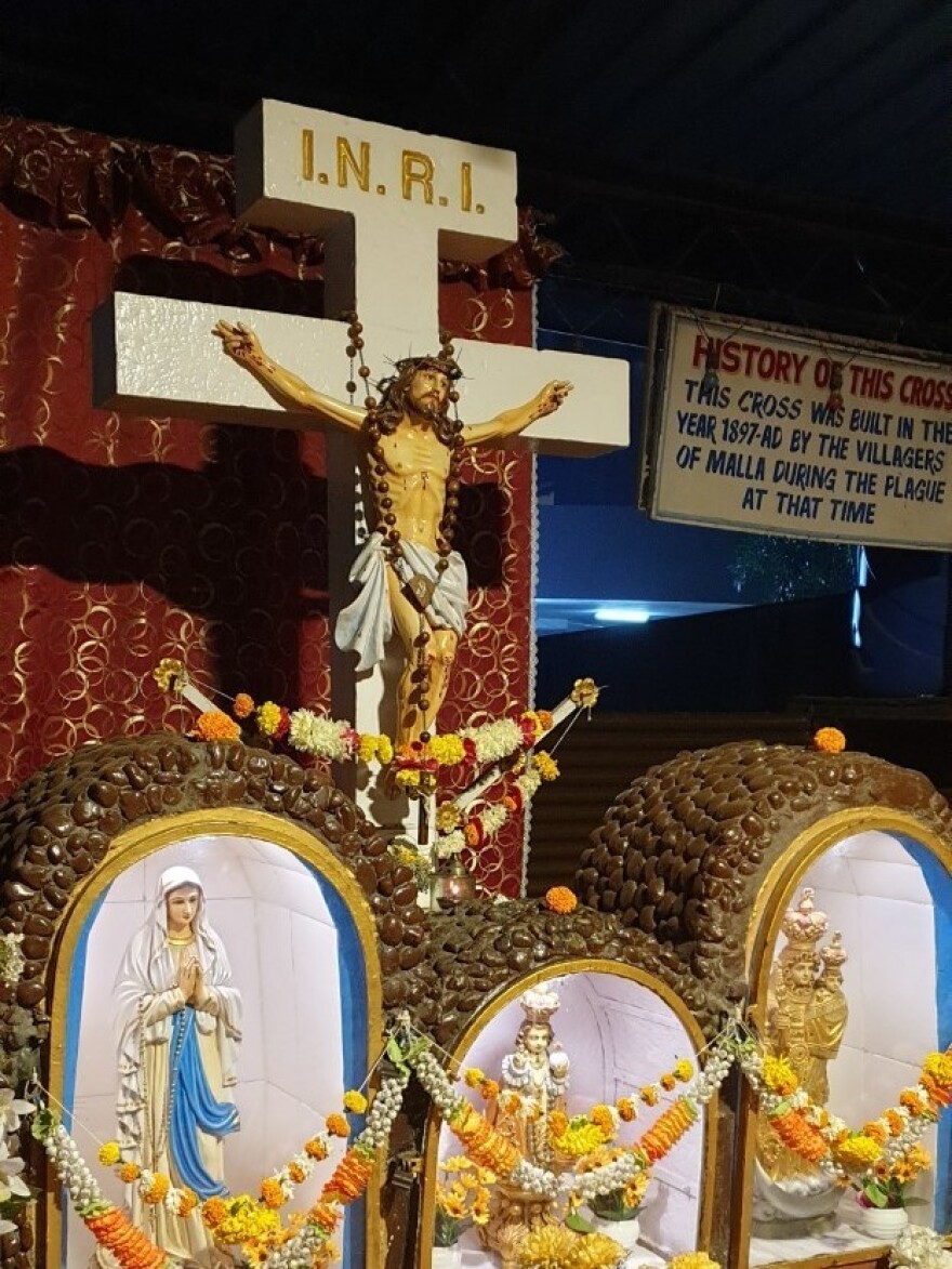 In a leafy Mumbai suburb, garlands adorn a roadside cross that was erected in 1897, when the city was battling the bubonic plague.