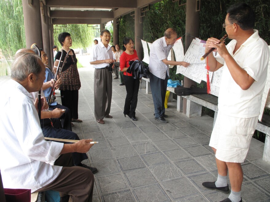 Retirees in a Chaohu park play the song "Chaohu Is Good" on the <em>erhu</em>, a traditional Chinese instrument. So far, opinions are split on whether dividing the city will be good for their future.