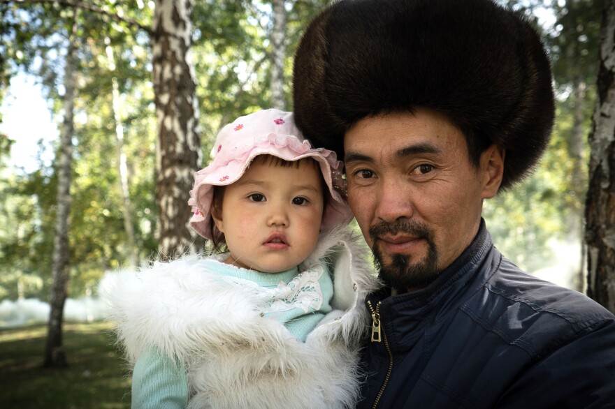 A Kyrgyz performer at the games poses with his daughter.