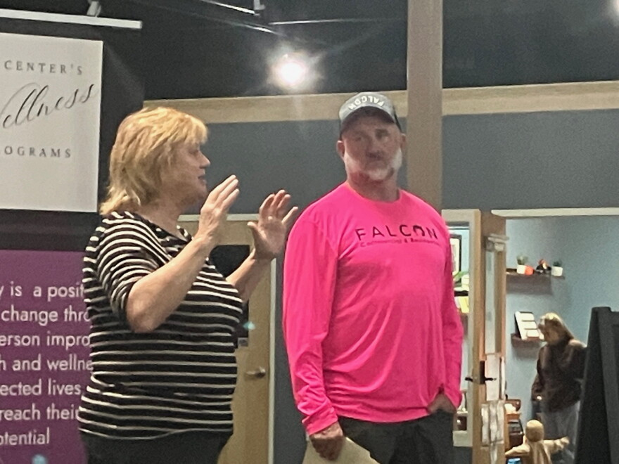 The Center director Pennie Kellenberger speaks Wednesday, as Shawn Manning of Falcon Home Improvement looks on.