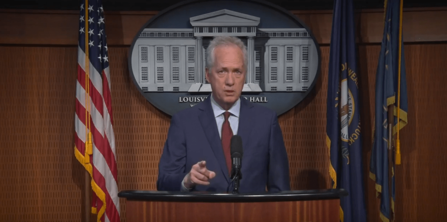 Louisville Mayor Greg Fischer stands at a podium during a pre-recorded address to the Metro Council in April. 