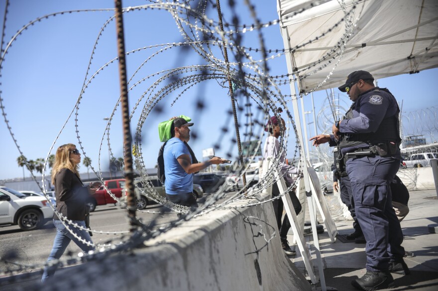 An Immigration and Customs Enforcement agent checks pedestrians' documentation at the San Ysidro Port of Entry in San Ysidro, Calif., on Oct. 2.