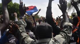 Protesters cheer Nigerien troops as they gather in front of the French Embassy in Niamey during a demonstration that followed a rally in support of Niger's junta in Niamey on July 30, 2023. Thousands of people demonstrated in front of the French embassy in Niamey on Sunday, before being dispersed by tear gas, during a rally in support of the military putschists who overthrew the elected president Mohamed Bazoum in Niger. Before the tear-gas canisters were fired, a few soldiers stood in front of the embassy to calm the demonstrators. (Photo by AFP) (Photo by -/AFP via Getty Images)