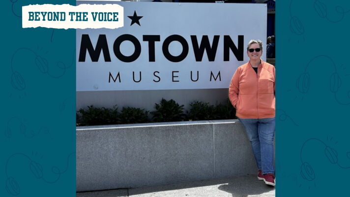 A woman wearing sunglasses smiles next to the Motown Museum sign.