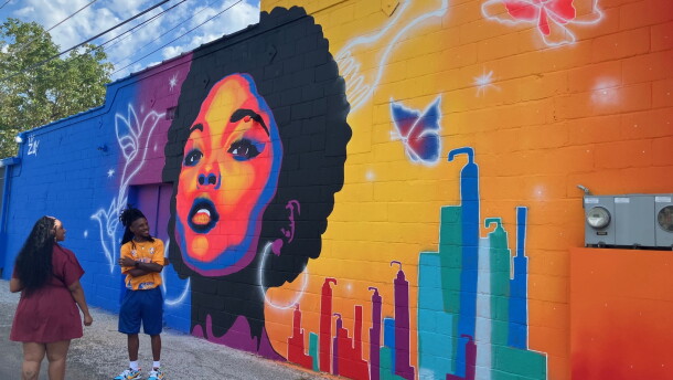 Rock Island artist Zay Williams celebrates the dedication of his new mural on the side of Celebrity's Beauty Supply, 1600 Harrison St., Davenport, on Friday, Sept. 4, 2026.