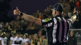 A high school referee signals during a game this season.