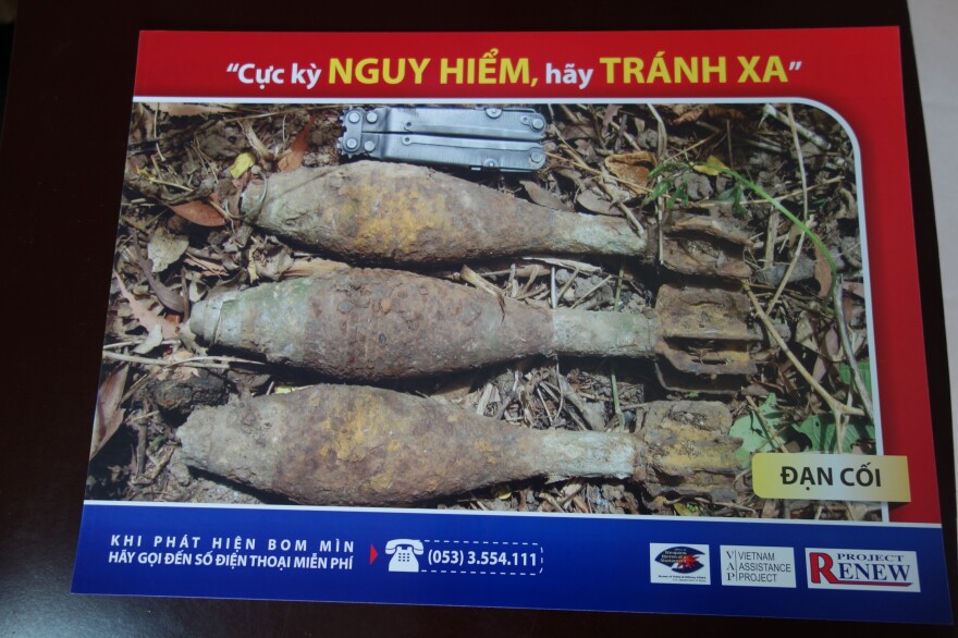 A sign created by Project Renew shows mortar shells and warns, "Extreme danger, keep out, stay away."