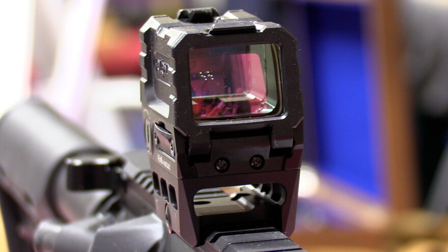 A holographic electronic sight on top of a semiautomatic rife.